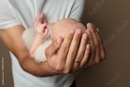 The child's head is lying in the father's arms, the child's view from the back of the head	