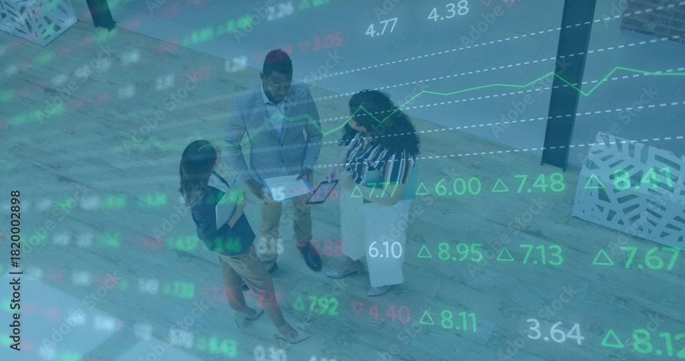 Obraz premium Standing three staff in suits reviewing tablet, folder on wood floor, planter and market overlay