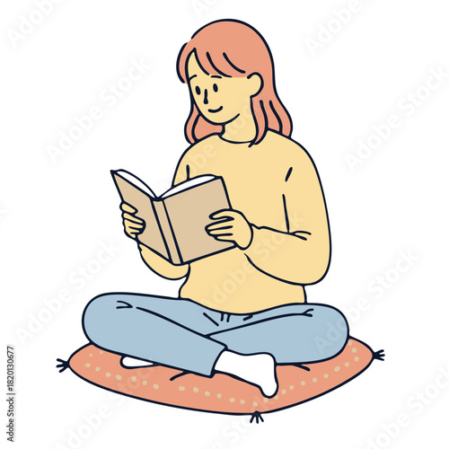 Young woman reading book sitting cross legged on cushion, relaxed and peaceful mood