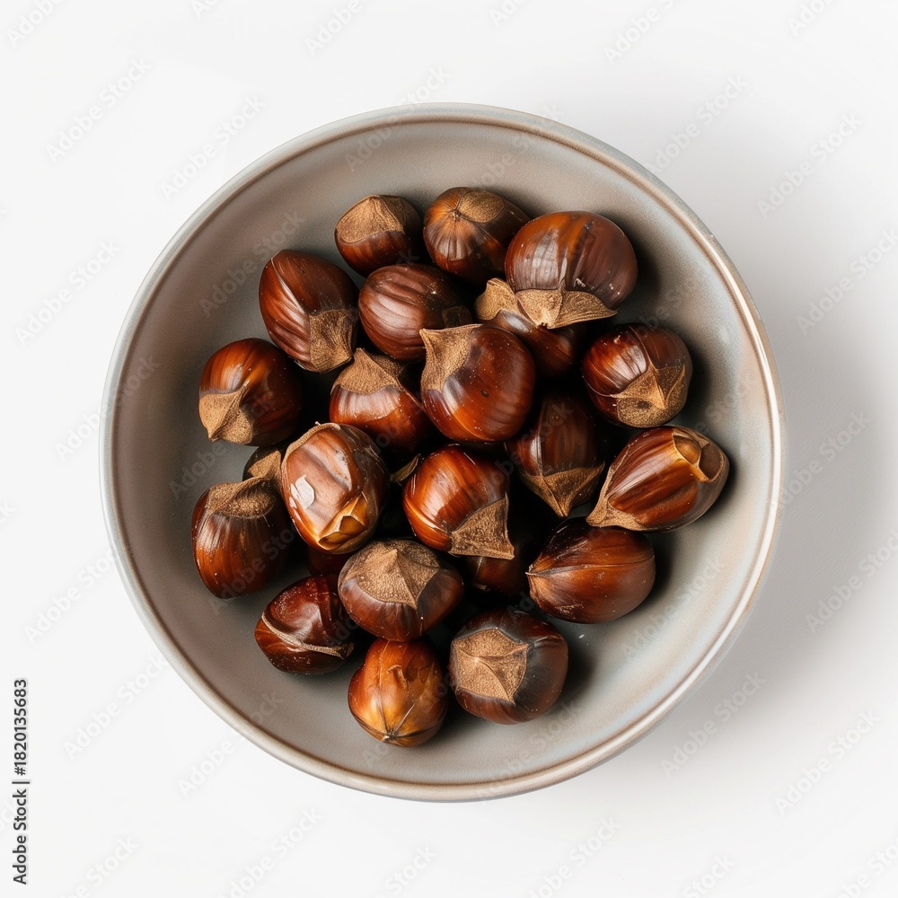 Obraz premium Flat lay of roasted chestnuts in bowl on white background, clean studio mockup, food concept.