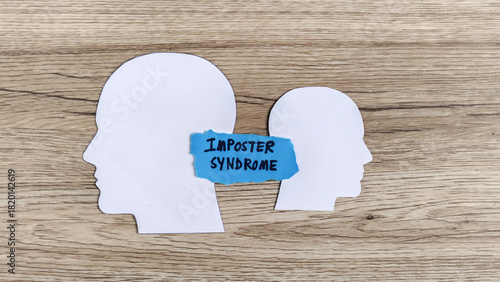 Imposter Syndrome Concept: Paper Cutout Heads with Blue Text Representing Self-Doubt and Achievement Anxiety