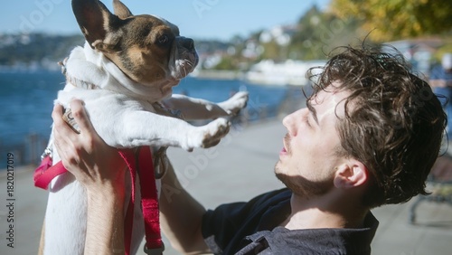Man Holding French Bulldog by the Water