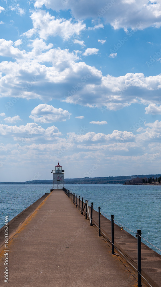 Fototapeta premium The Two Harbors Pierhead Light at the end of a rock and concrete pier that protects Agate Bay on the North Shore of Lake Superior in Minnesota.