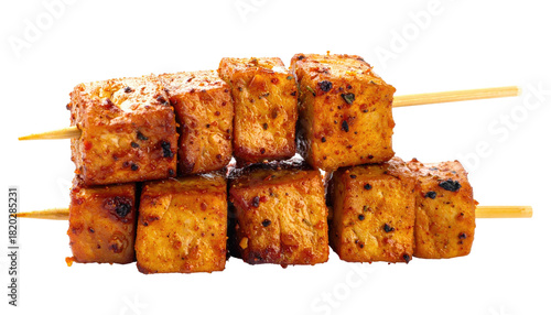 Skewered, seasoned, golden-brown tofu cubes presented against a black background