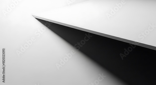 Sharp edge of a dark blade against a bright white background creating a stark and minimalist contrast