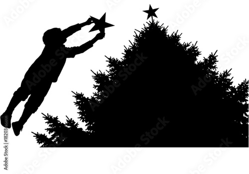 Silhouette of a child reaching to place a star on a Christmas tree.