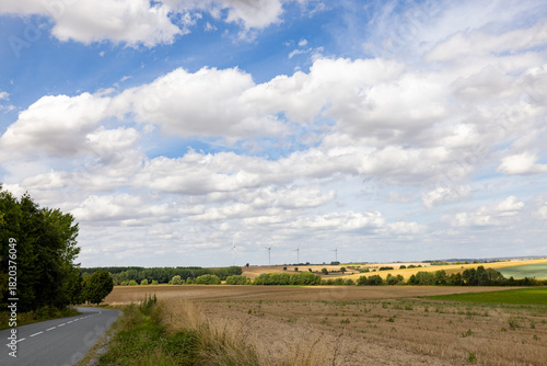 Epernay, Marne, Grand-Est, France, August, 28th, 2025, Champagne Area, Vast farmland stretching under expansive sky, Serene countryside road amid cultivated fields under wide clouds