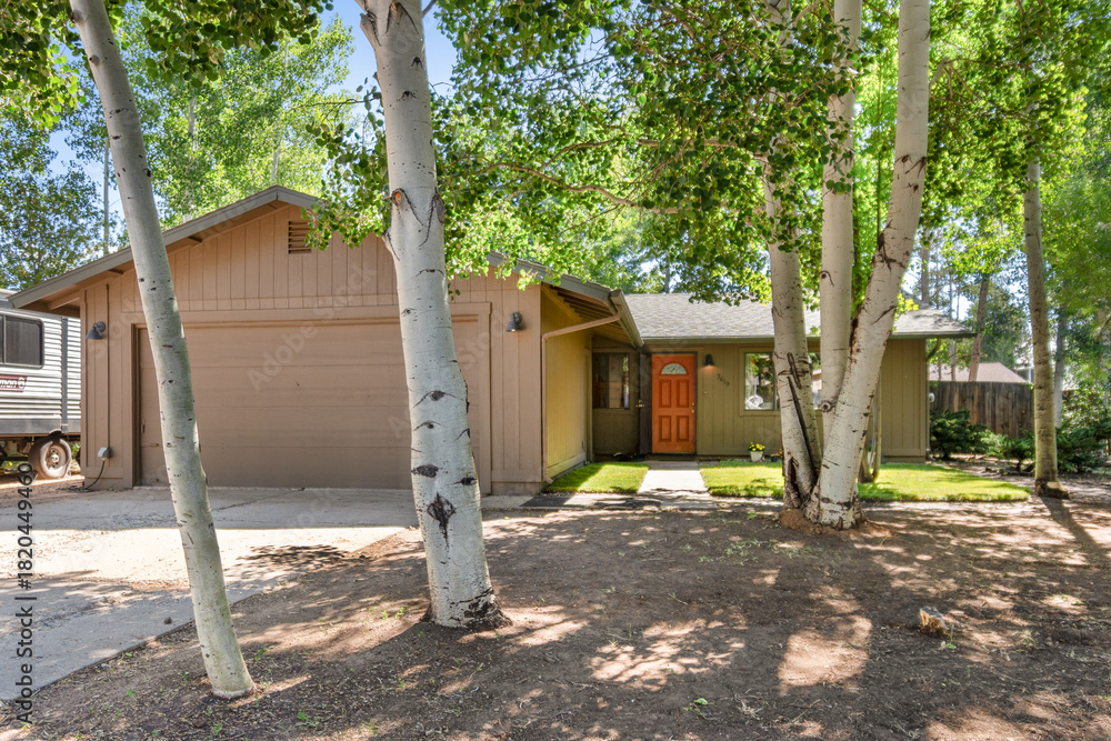 Fototapeta premium A house with a trailer in front, surrounded by trees