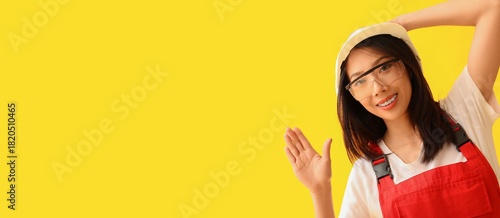 Asian female builder waving...
