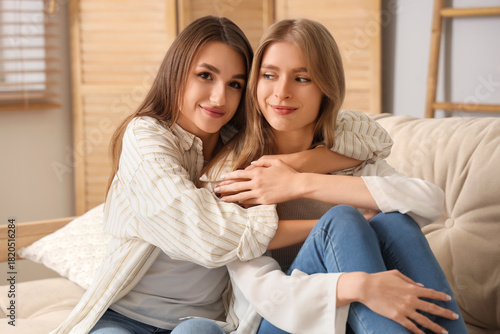 Young women hugging on sofa...
