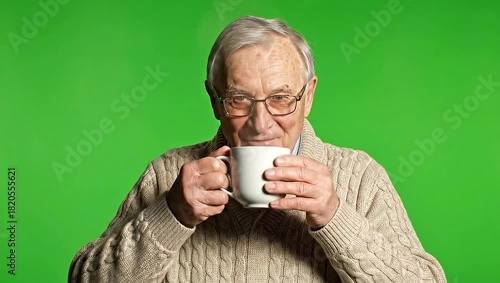 Wallpaper Mural Elderly man drinking hot beverage on green screen. Torontodigital.ca