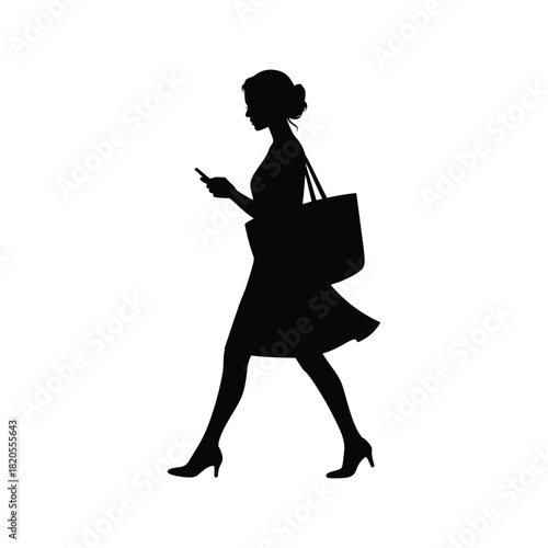 A stylish woman in silhouette, walking confidently while checking her smartphone and carrying a tote bag, isolated on