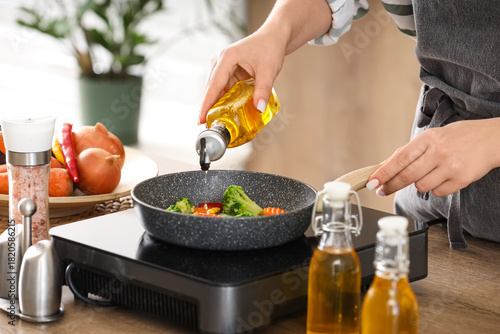 Woman frying vegetables wit...