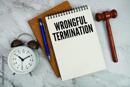 Photos Wrongful Termination text written on notepad with pen and judge gavel on marble