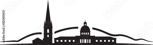 Silhouette of a city with a tall spire and mountains in the background at night