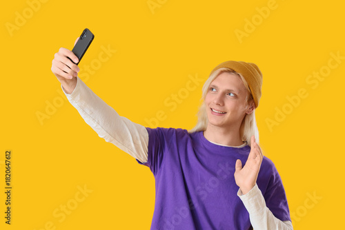 Young blonde man in hat wit...