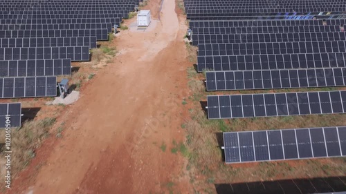 Drone point of view of a large solar farm with photovoltaic panels and wind turbines generating clean energy in Spain promoting sustainable practices.
