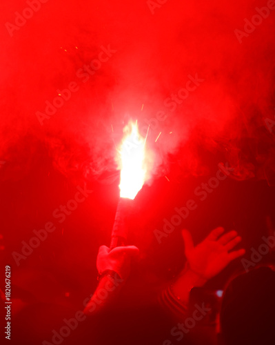 A person holding a red torch in a crowd