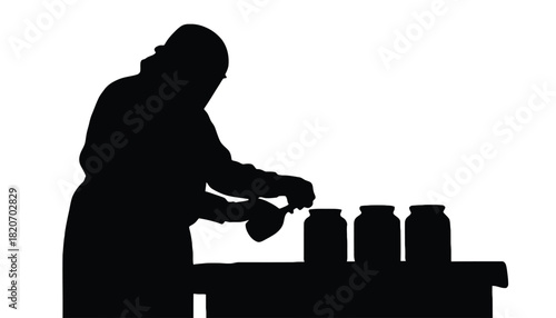 Person in silhouette carefully preserving food in glass jars on a table