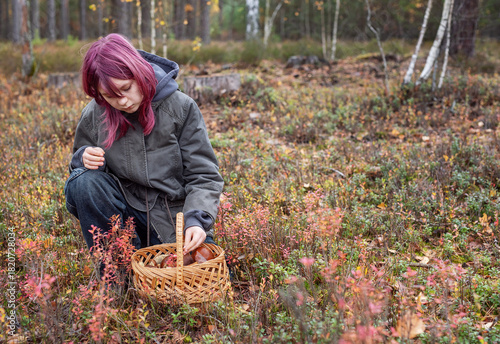 Girl foraging wild mushrooms in autumn forest