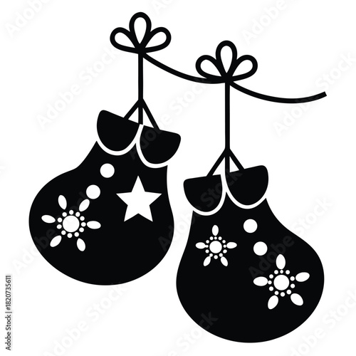 Stylized winter mittens are hanging on a decorative string, in black and white