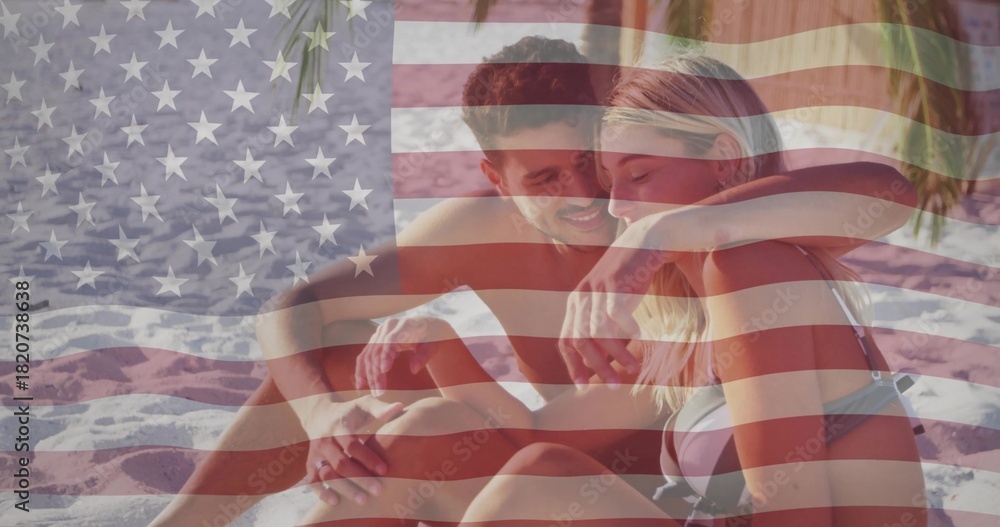 Naklejka premium Sitting couple embracing on rippled sand, wearing bikini top and swim trunks, US flag overlay