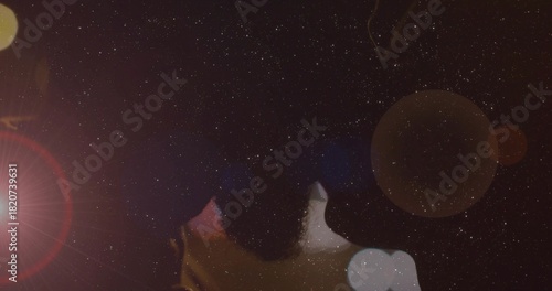 Картината върху платно Gazing couple wearing dark clothing at night under dense star field with lens fl