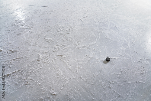 Photography An ice hockey puck in the goal, on textured ice with skate tracks