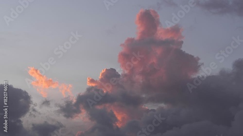 Colorful clouds at sunset with shades of pink and gray. The sky is partially cloudy, creating a serene atmosphere.