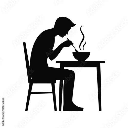 Silhouette of a person eating a steaming bowl of food at a table