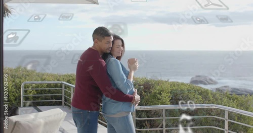 Woman holding mug, man approaching, cradling belly on deck, tech icons overlaying couple, bonding