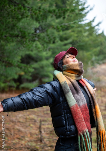 Relaxed woman breathing fresh air in the autumn mountain  and making breathing exercises 