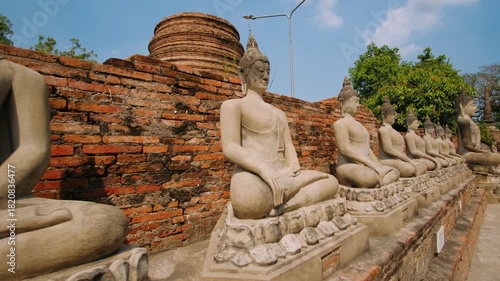 Meditating Buddha statues at Wat Yai Chai Mongkhon temple in Ayutthaya Historical Park, Thailand. UNESCO World Heritage Site.