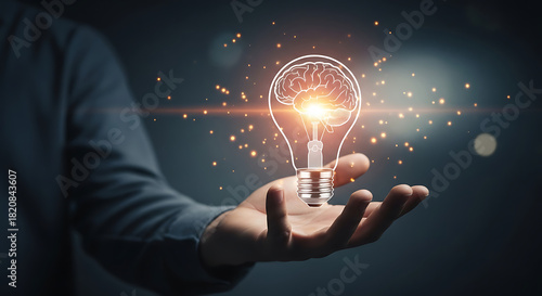 A hand holding a lightbulb with a brain inside symbolizing creative ideas and innovation process