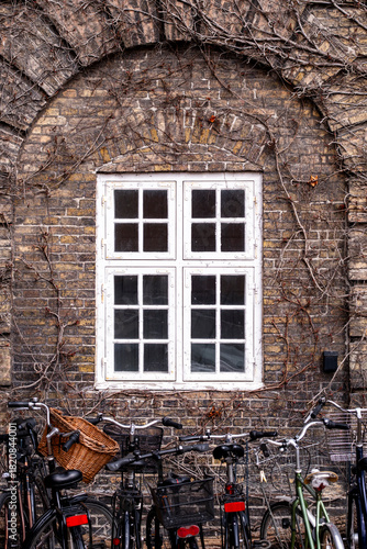 Brick architecture facade with window detail and bicycles in Copenhagen emphasizing texture and contrast within a clearly structured exterior view intended for broad visual communication