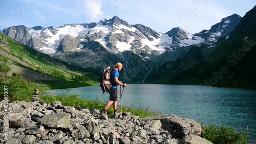 a man on the shore of the mountain lake Poperechnoye in Altai