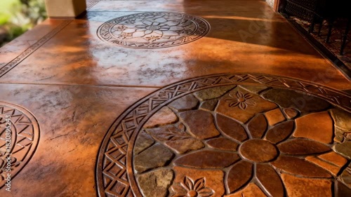 Medium shot of a stamped concrete patio showcasing intricate patterns and rich earth tones highlighting the artistic finishing on the surface.