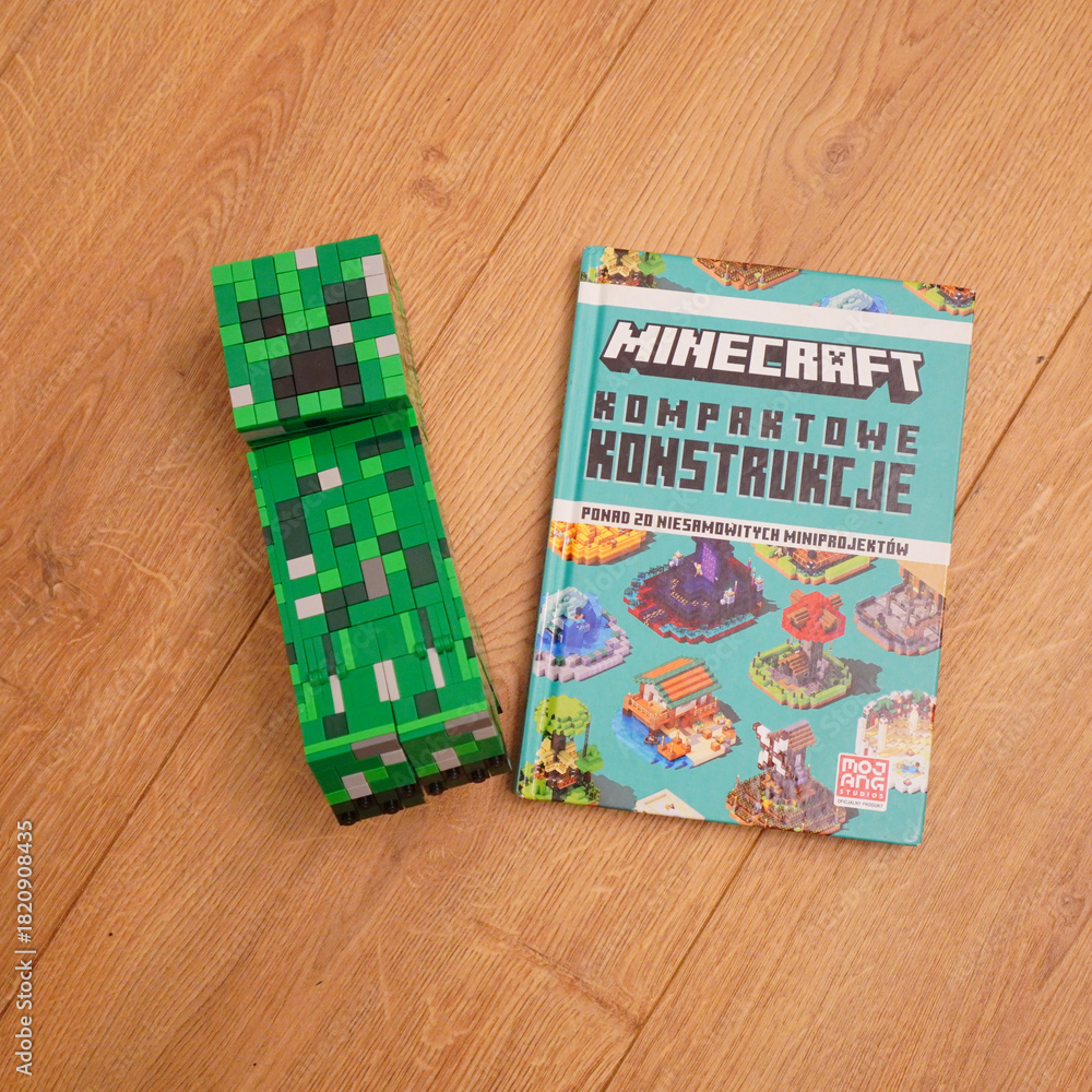 Naklejka premium Minecraft Creeper figure and construction book on a wooden surface