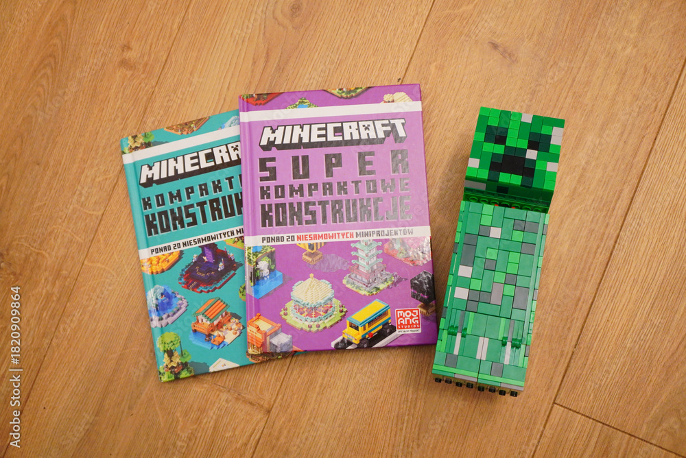Fototapeta premium Minecraft books and Creeper figure on a wooden surface, top-down view