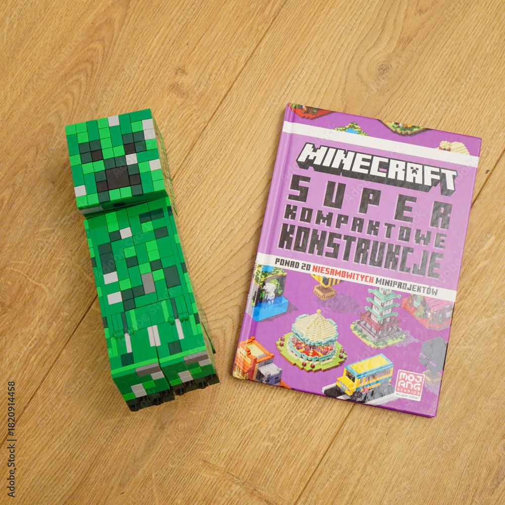 Naklejka premium Minecraft Creeper figure and book on a wooden surface