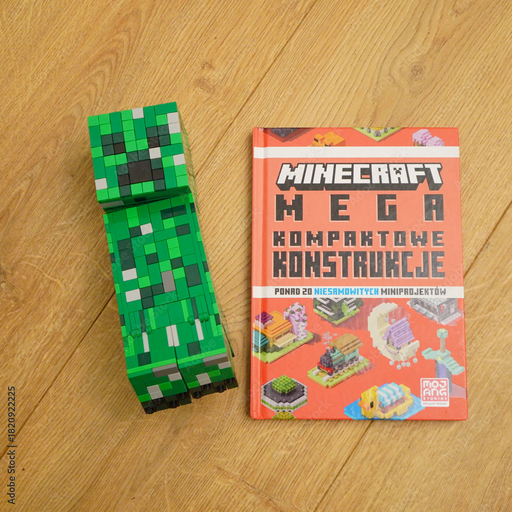 Naklejka premium Minecraft Creeper figure and Mega Kompaktowe Konstrukcje book on wooden surface