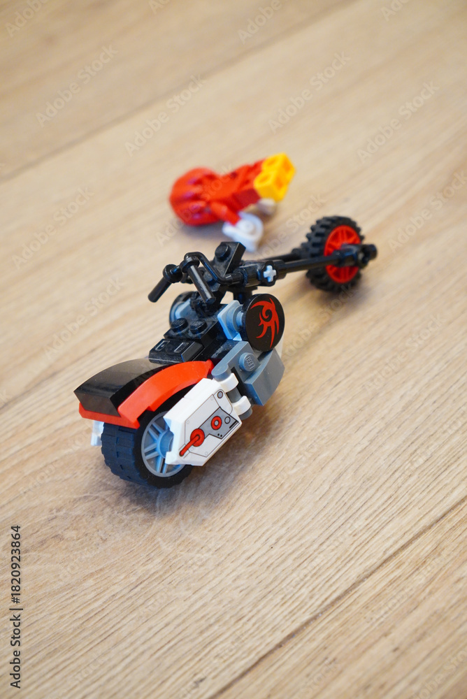Naklejka premium A cool Lego motorcycle toy with a red and black color scheme on a wooden surface