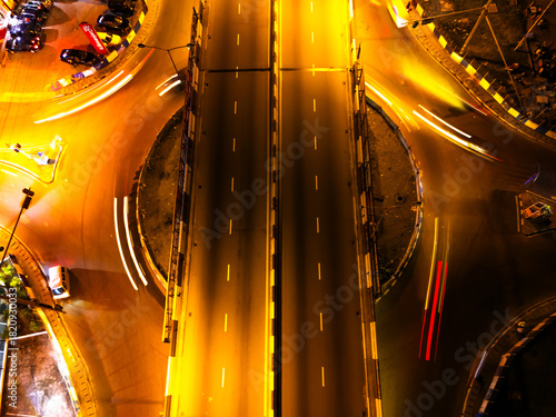 Aerial view of GRA Junction pulsating with streaks of light from circling vehicles, illuminating the vibrant roundabout, Port Harcourt, Rivers State, Nigeria.