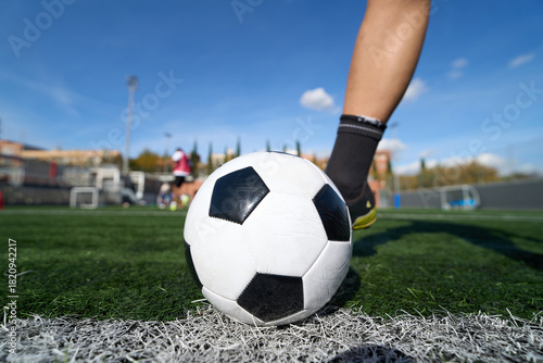 Soccer player getting ready to kick ball on field