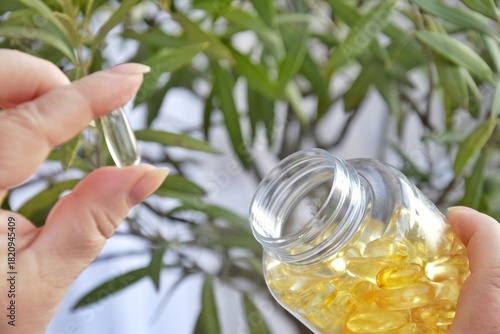 A woman holds Omega-3 vitamin capsules