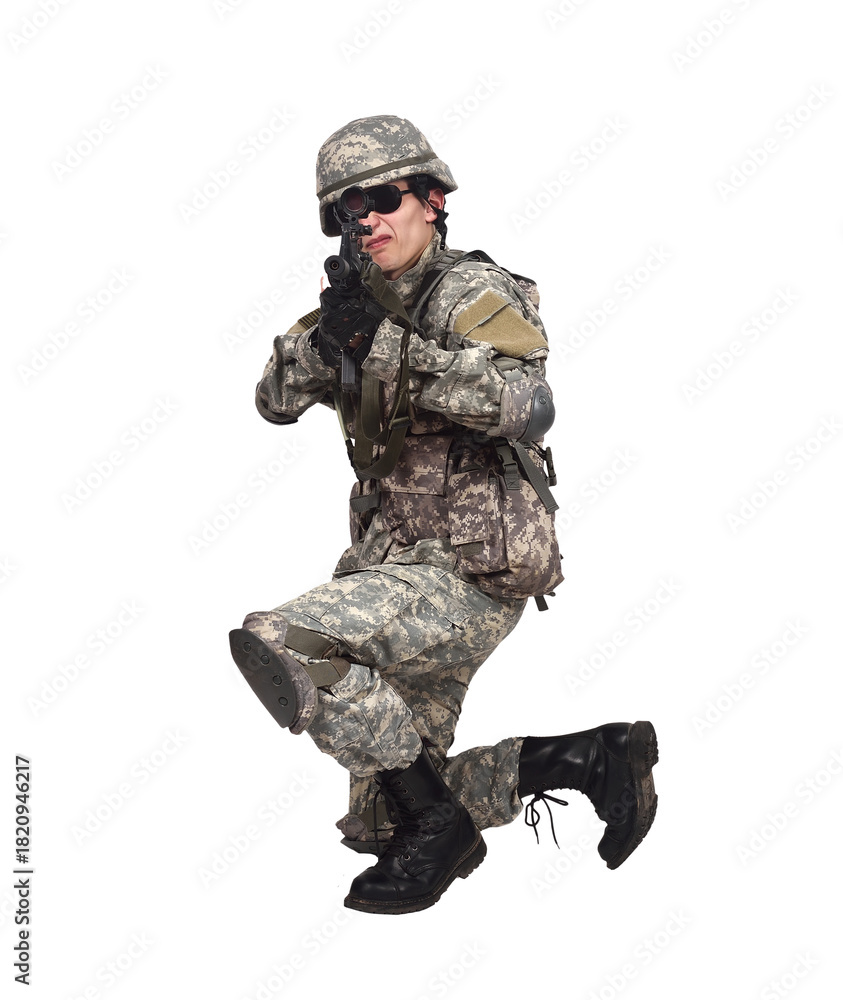 Fototapeta premium A soldier in camouflage clothing kneels and aims a rifle