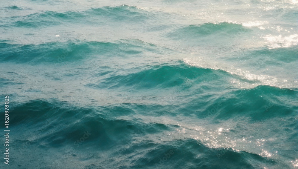 Fototapeta premium Close-up of turquoise ocean waves with sunlight reflections.