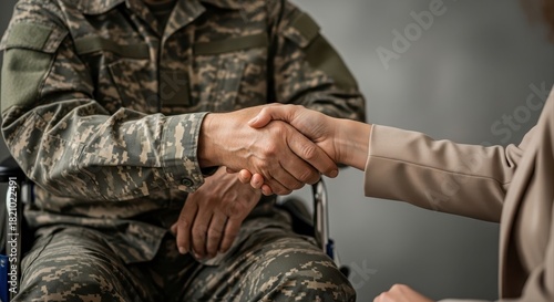 disabled veteran in camouflage uniform shaking hands with civilian woman. soldier sitting in wheelchair. gratitude, respect and support concept. banner with copy space. social services.