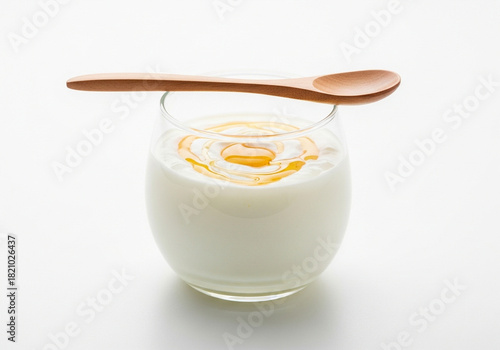 A cup of Greek yogurt with honey on a clean white background