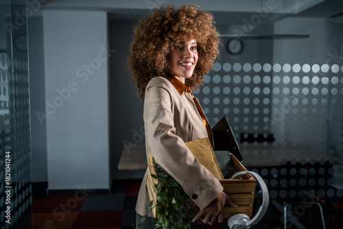 Photos Happy businesswoman carrying personal box leaving office